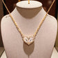 Gold necklace with a heart-shaped pendant on a mannequin bust.